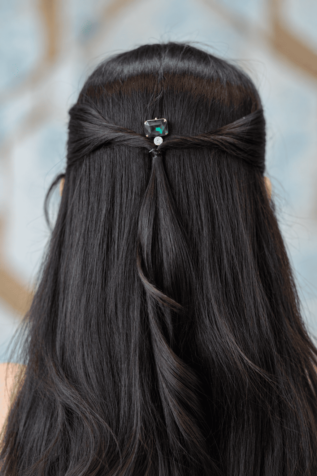 Green crystal hair pin styled in a half-up hairstyle