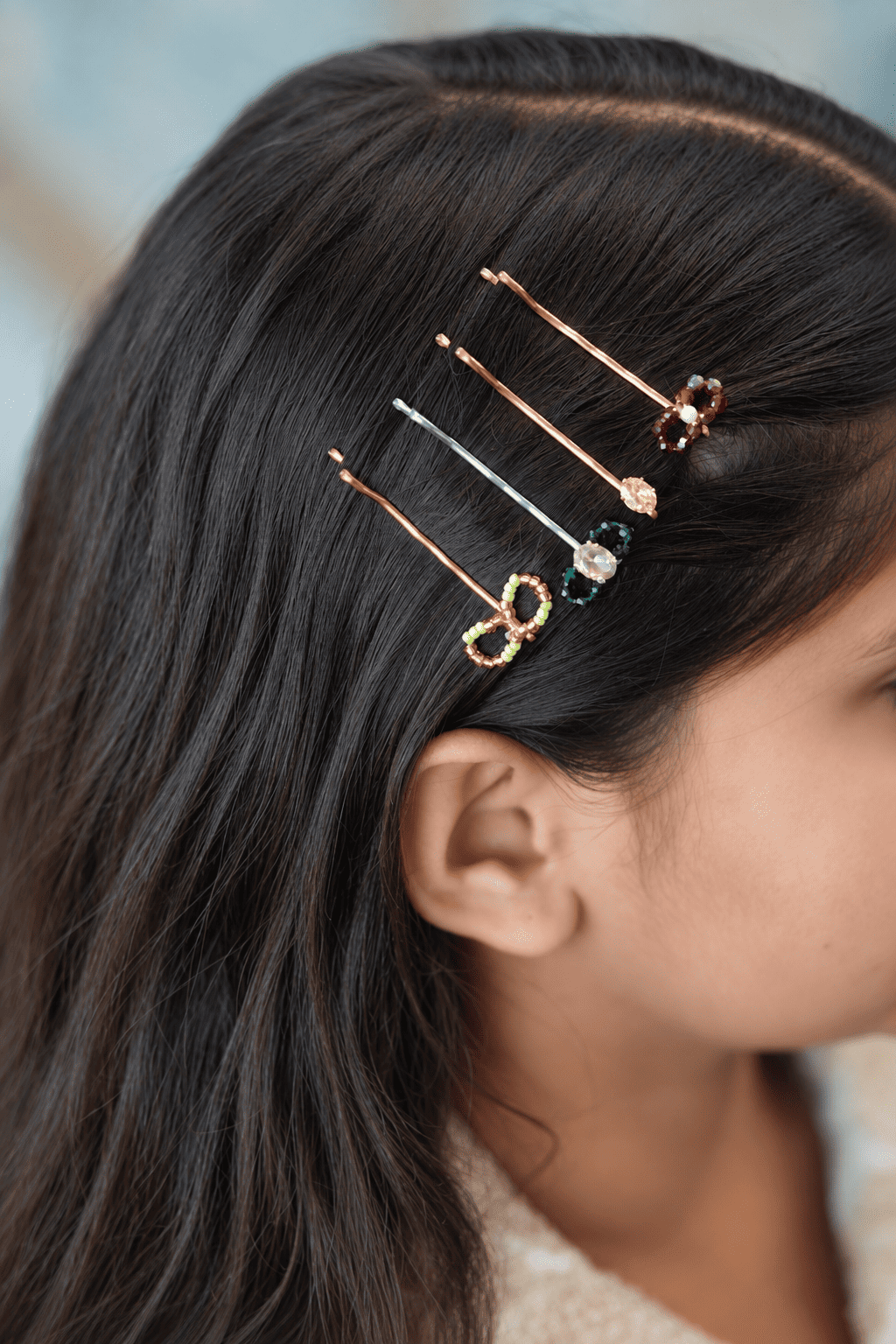 Colourful beaded hair pins for girls styled in dark hair