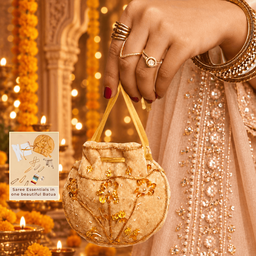 Woman in festive attire carrying a beige handcrafted velvet Saree Survival Kit batua