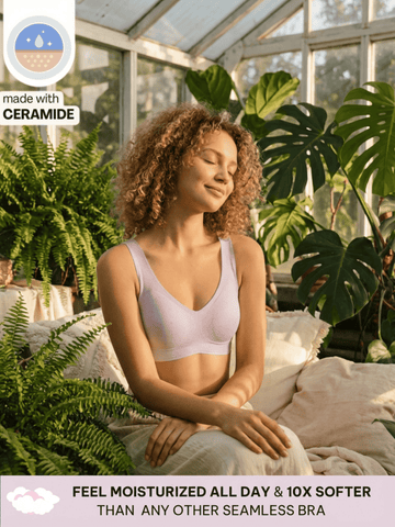 Woman sitting in a greenhouse wearing a pale lilac ceramide infused comfort bra, surrounded by plants.