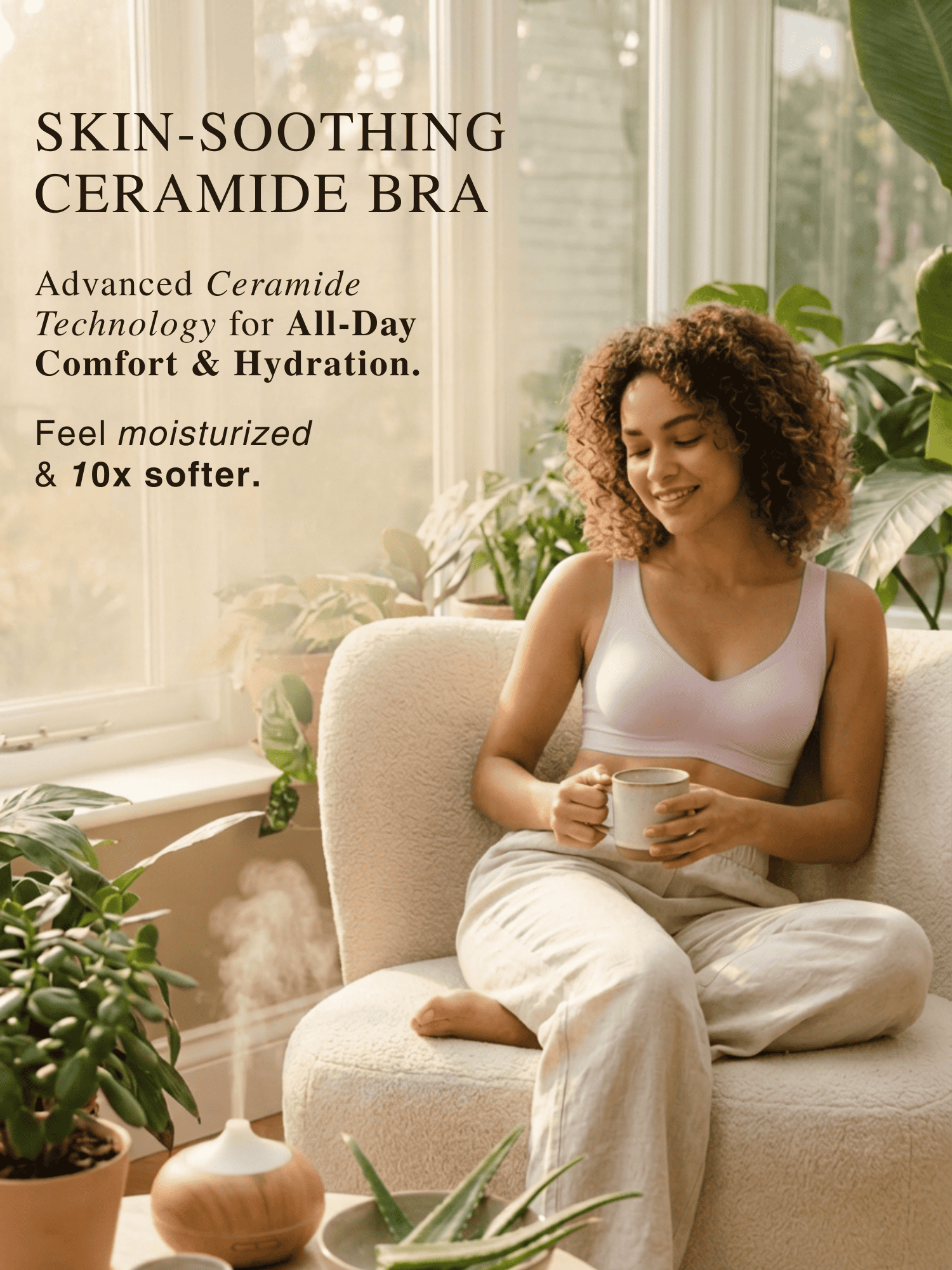 Woman sitting on a couch holding a mug wearing skin-soothing ceramide bra during a hot summer day.