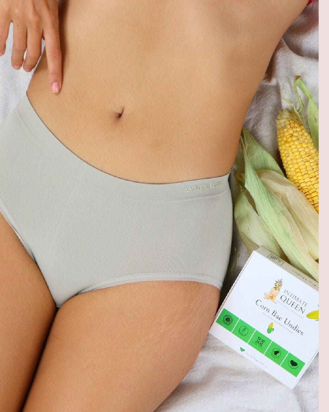 Person wearing dull green corn bae hipster underwear with it's outer package of underwear labeled 'Intimate Queen Corn bae undies"