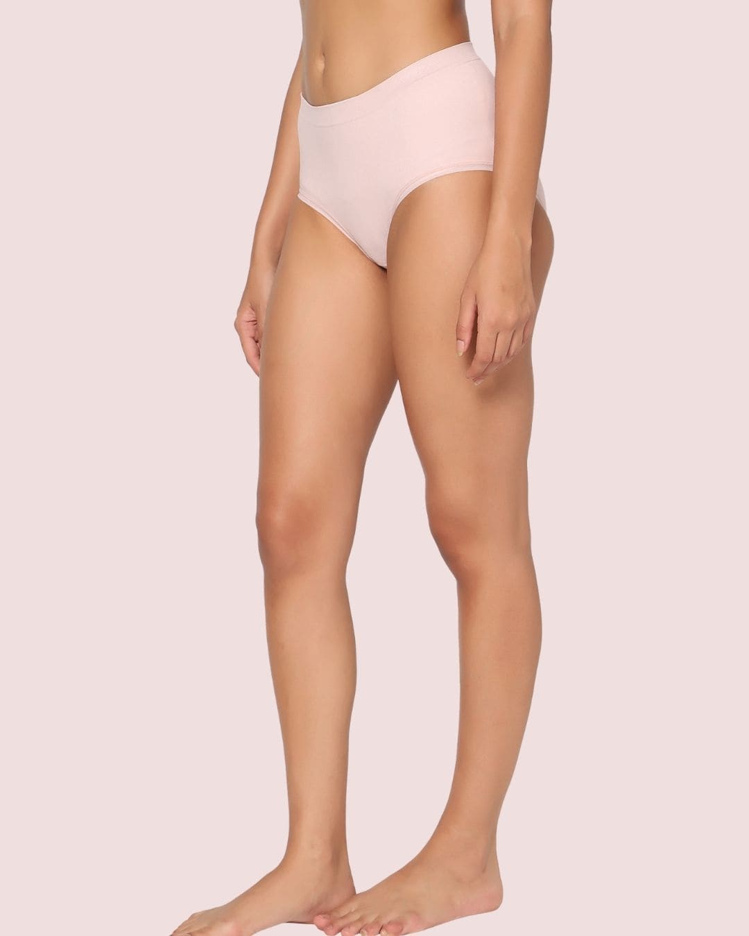 Person wearing light pink underwear on a plain background