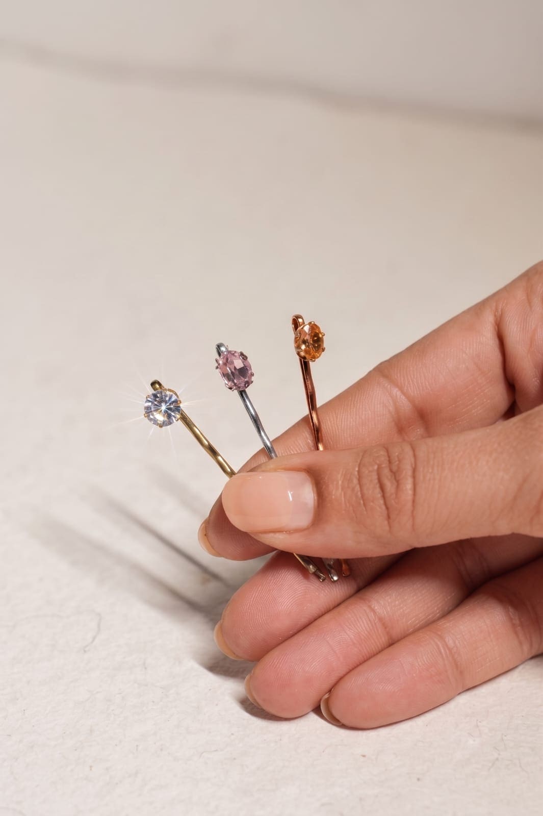Set of four gold-tone crystal bobby pins displayed on a neutral background