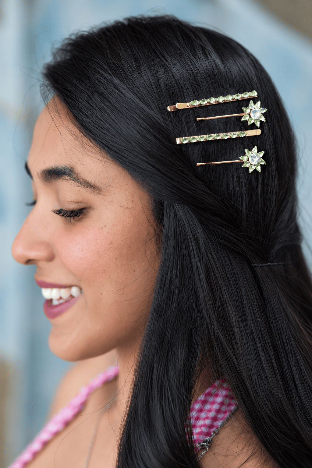 Green teardrop rhinestone hair clips styled in dark hair