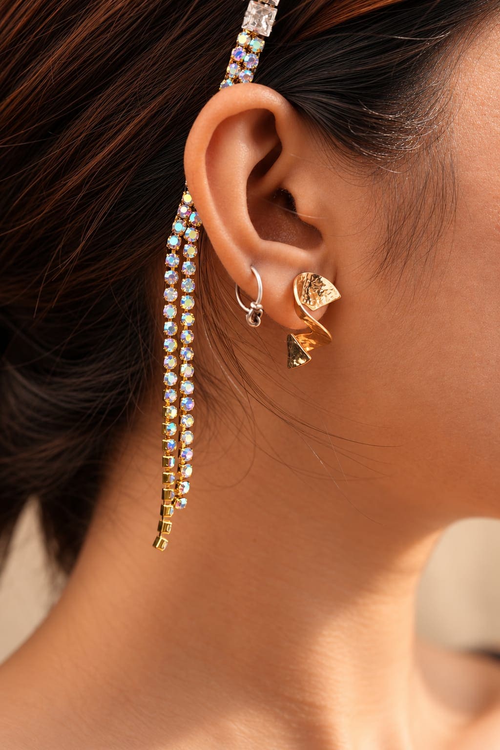 Macro close-up shot of the iridescent crystal tassel chains on the gold-toned base of the luxury IQ Edit hair accessory.
