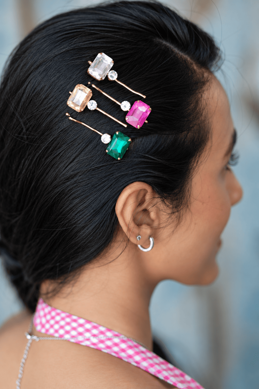 Colourful crystal bobby pins styled together in black hair