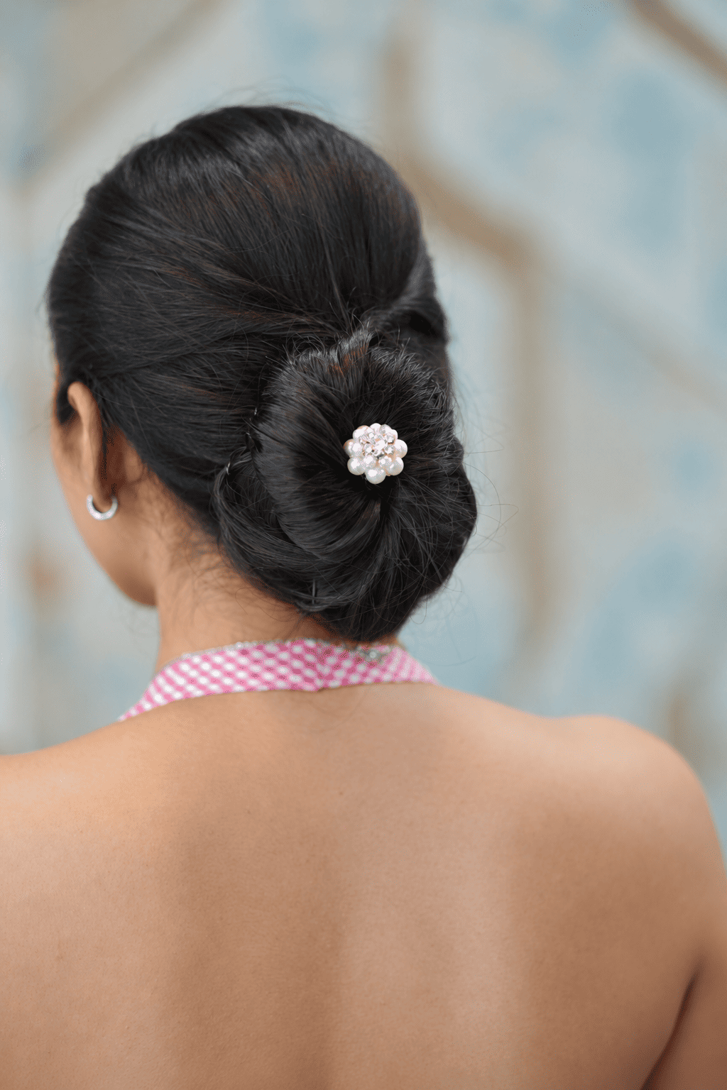 Pearl and crystal floral juda pin styled in a brunette bun hairstyle
