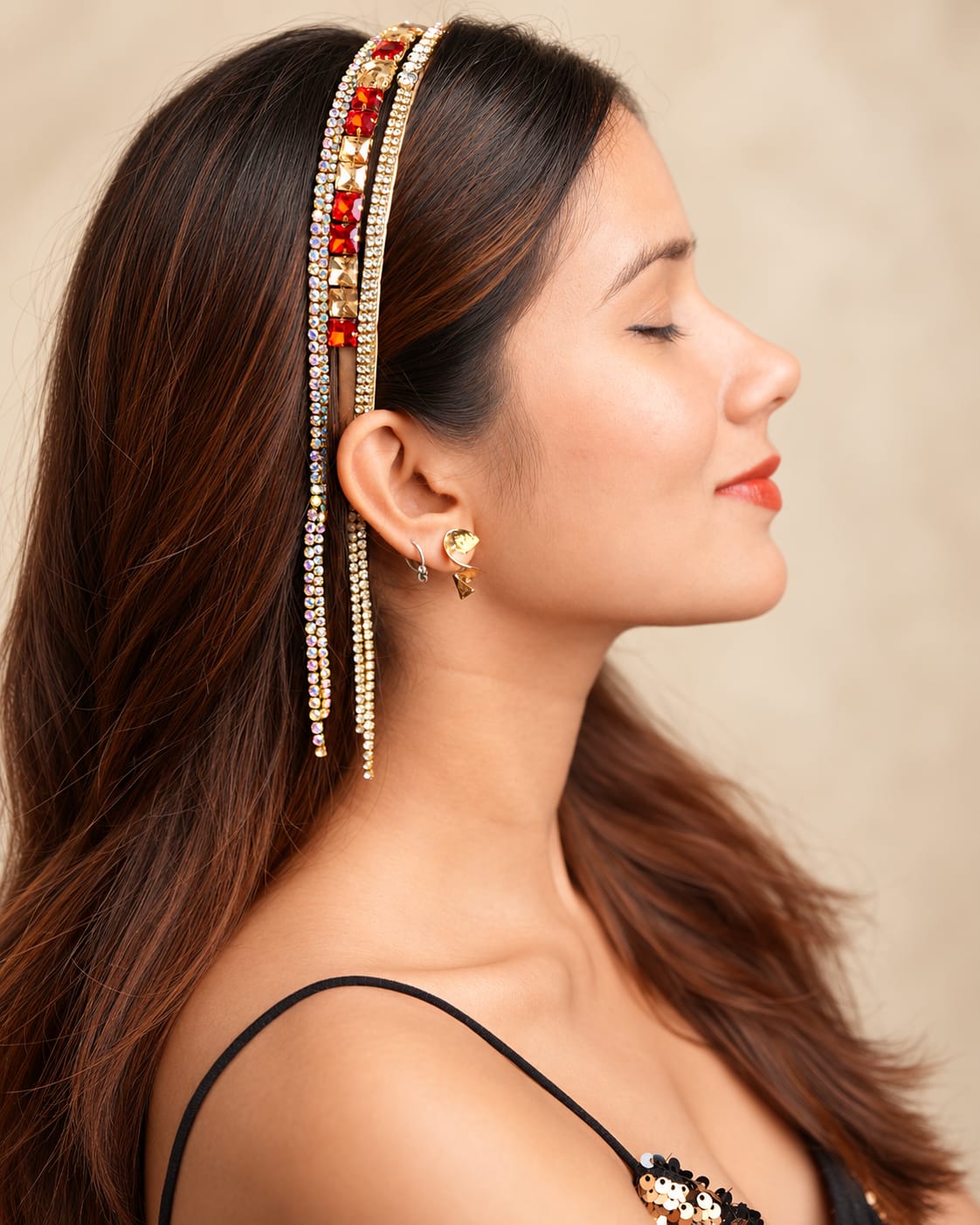 Gold-tone crystal tassel headband with red and champagne square stones, iridescent rhinestones and long dangling crystal strands worn by a model.