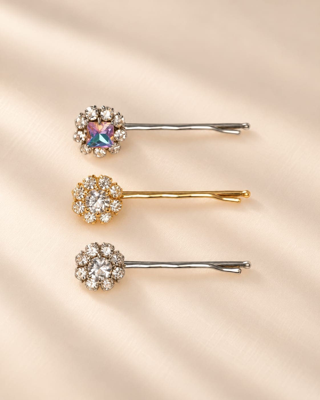 Set of three embellished crystal flower bobby pins on a neutral background