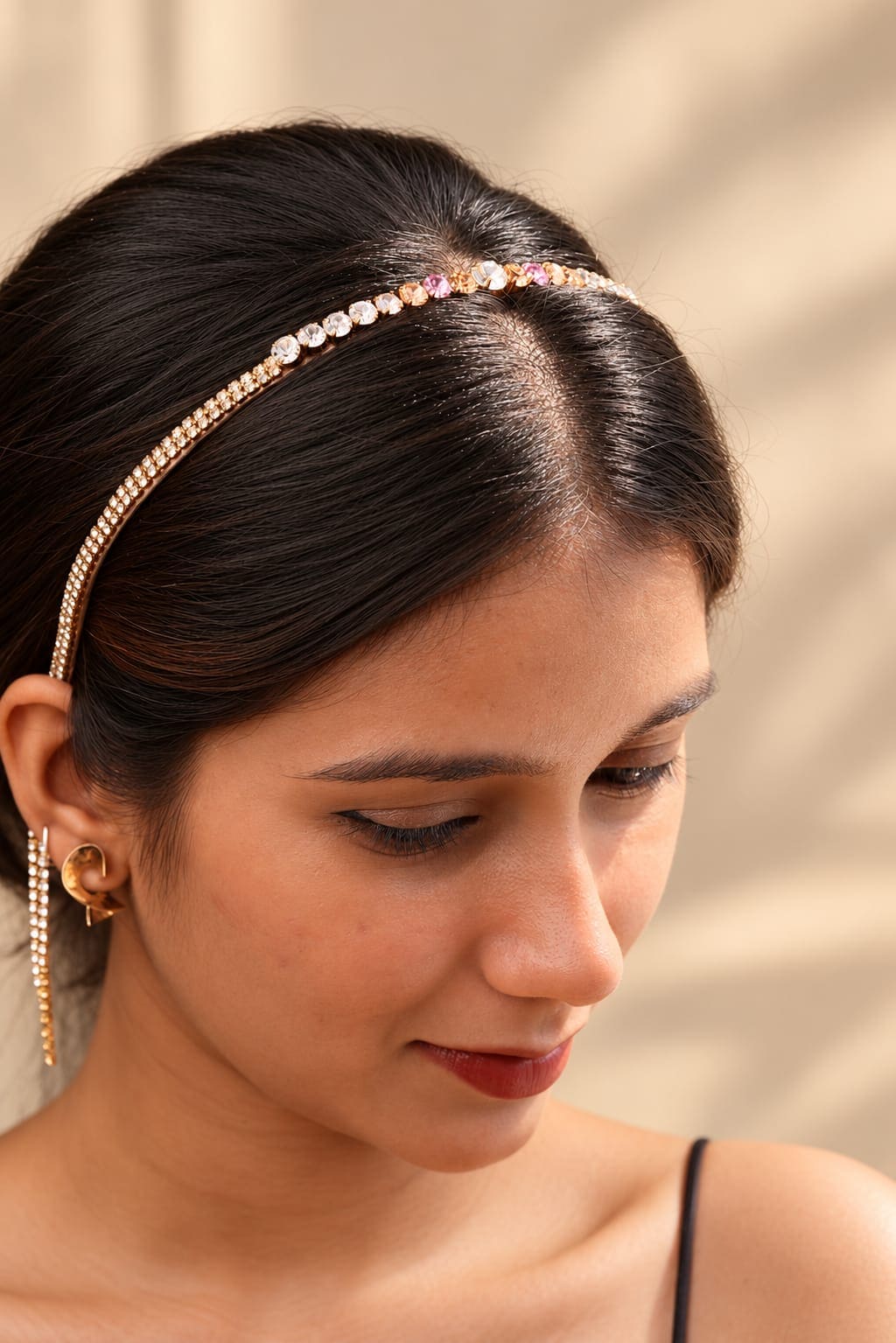 Gold-tone crystal rhinestone headband with graduated champagne and pink stones worn by a model