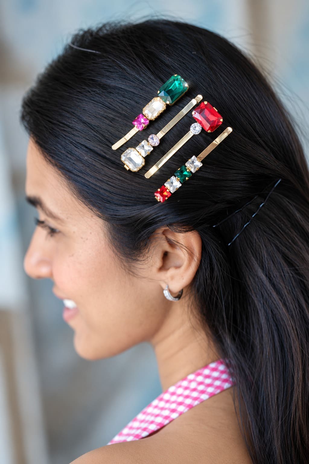 Multicoloured emerald green and ruby red crystal hair pins styled in dark hair.