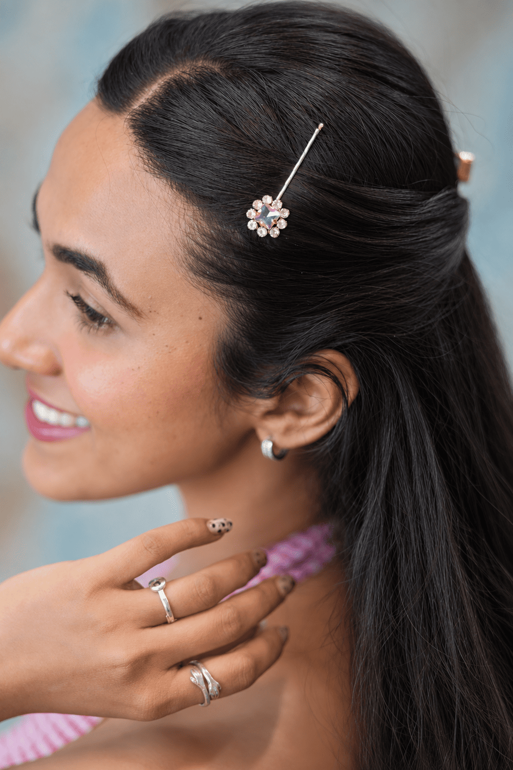 Smiling model wearing a vintage crystal bobby pin by IQ Edit to elegantly pin back the side of a half-up hairstyle.