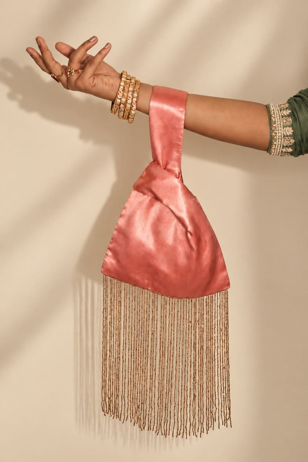 Close-up of the glossy dusty rose pink satin handle and knotted design of the Japanese knot bag